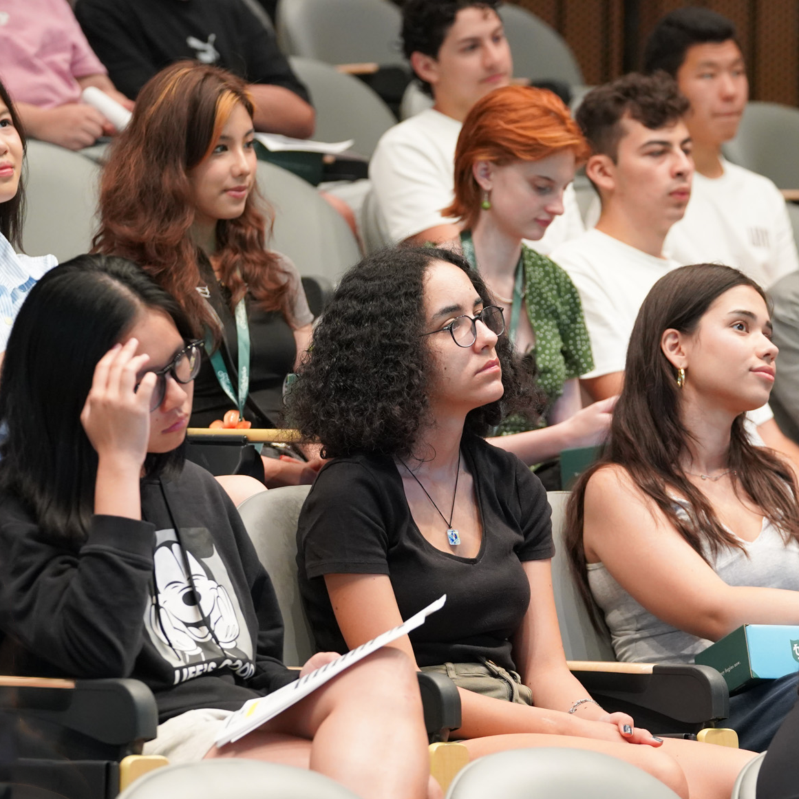 Students intently listen in a college lecture hall.