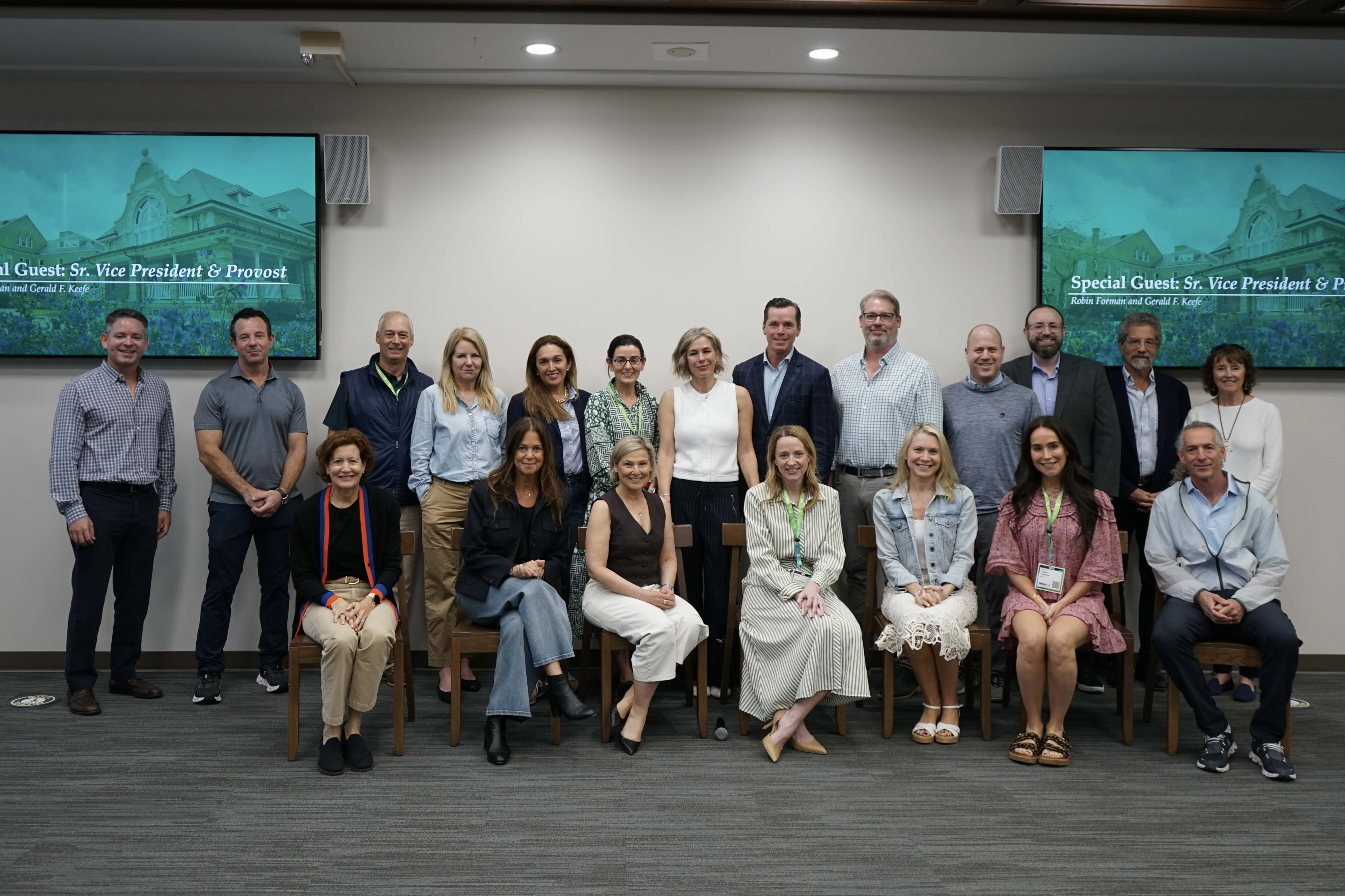 Group photo of 20 men and women smiling in an indoor meeting room.