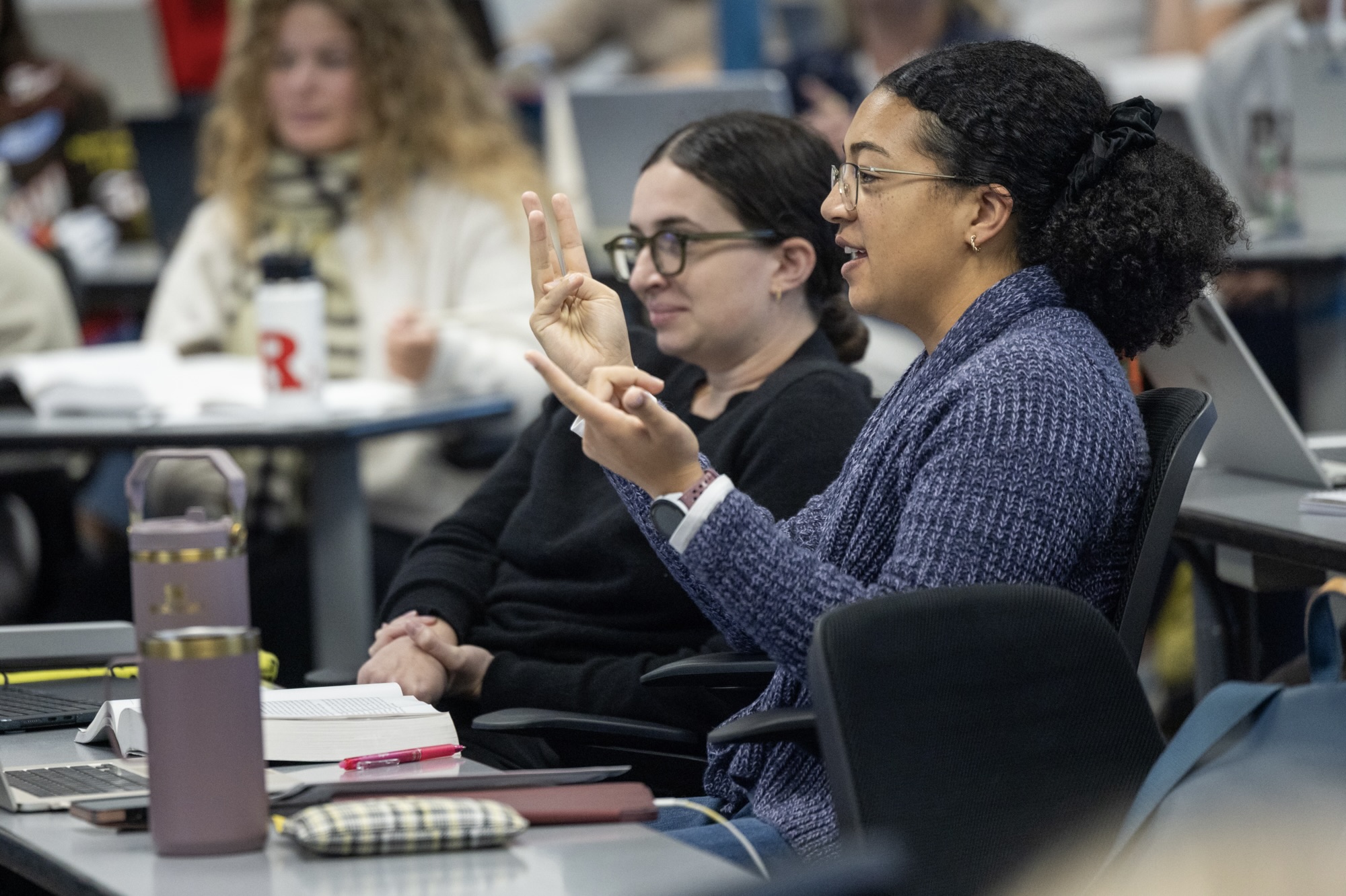 Students in a classroom answering a question