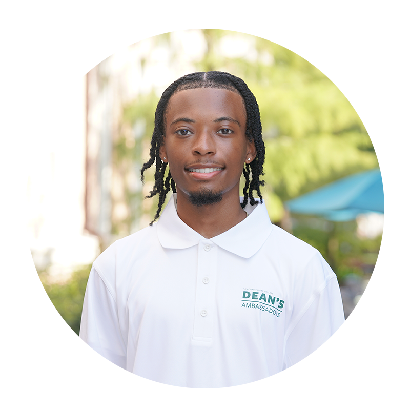 Young man smiling, wearing a white polo shirt outdoors