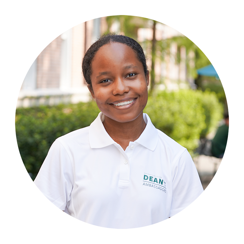 Smiling young woman in white polo shirt outdoors.
