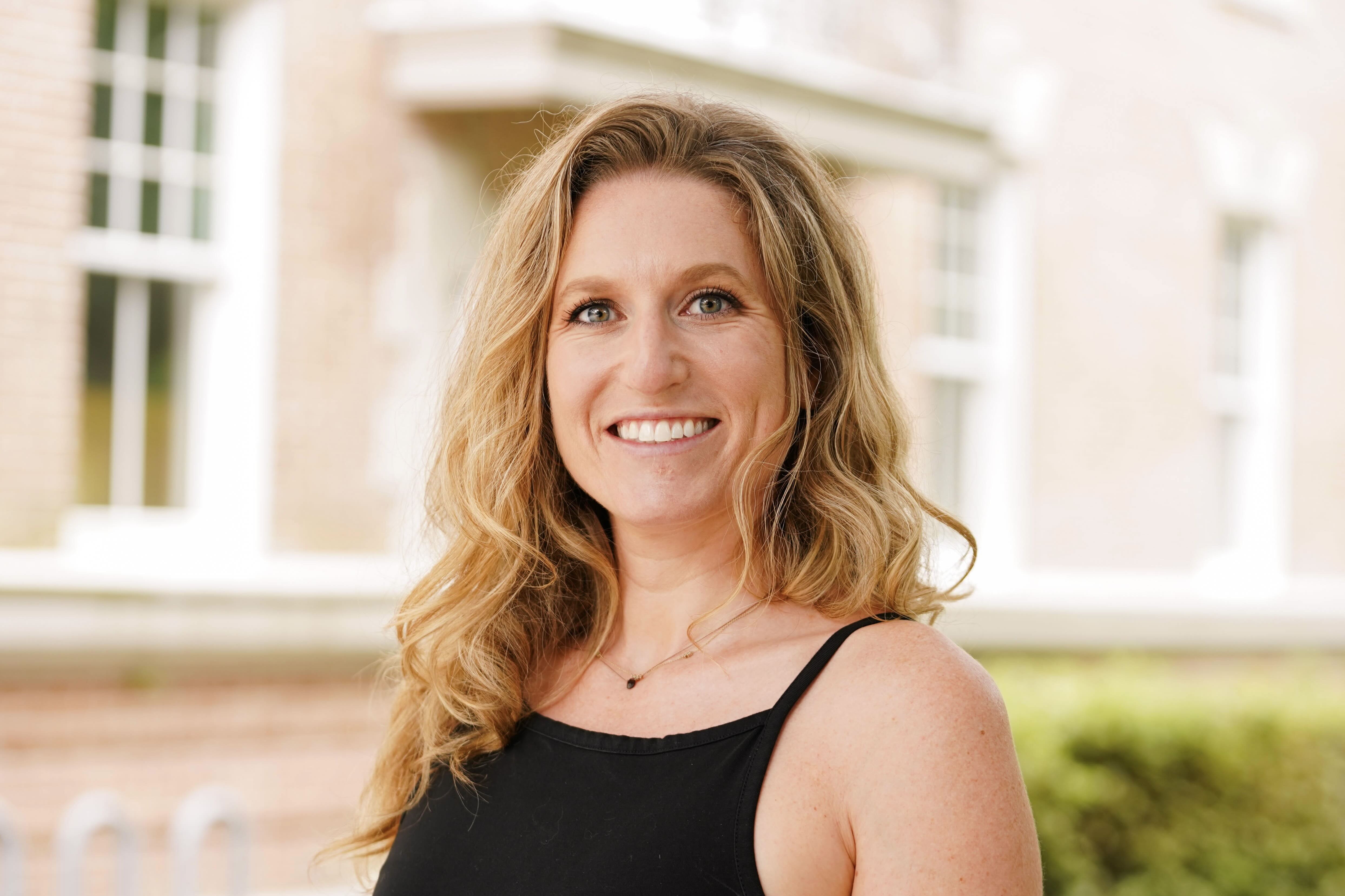 Headshot of a woman outside in front of a brick building