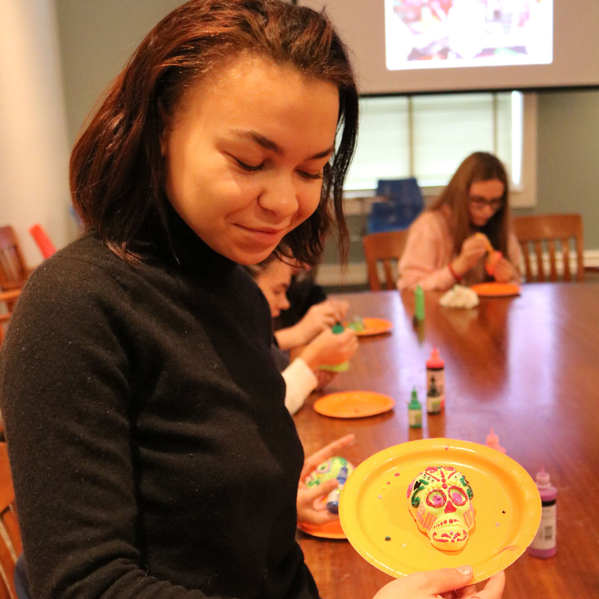 Student Holding Her Self-Painted Sugar Skull.